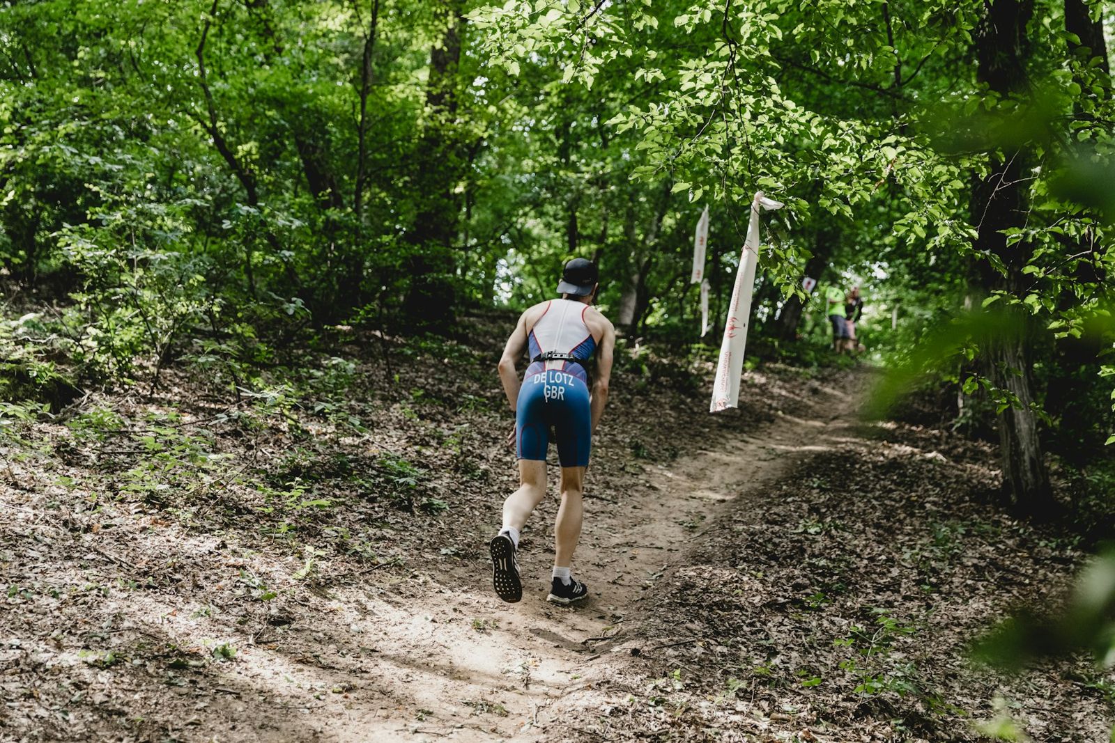 A runner power-walking up a steep forest trail